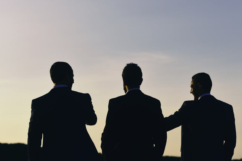 Silhouettes of three men talking at sunset